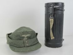 A WWII German gas mask tin with reproduction SS ski cap.
