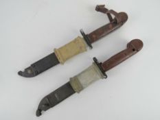 Two AKM bayonets, each with with scabbard and frog.