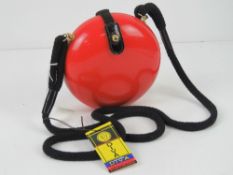 A c1960s Italian pop art style purse in red, marked for Diva with original label, 15cm diameter.