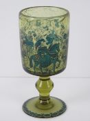 A green glass footed goblet having hunting scene in blue upon featuring lady on horseback,