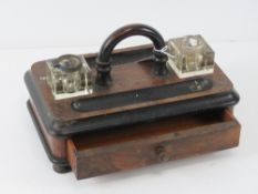 A Victorian desk organiser having two pen trays with single drawer under, twin glass inkwells (a/f).