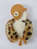 An overlaid plastic brooch in the style of Lea Stein in the form of a 1930s woman in hat and