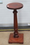 A turned mahogany torchere stand raised over square shaped base, 77cm high.