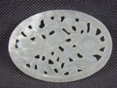 A pierced oval green jade Oriental disc, 8 x 5.5cm.