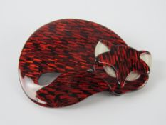 An overlaid plastic brooch in the style of Lea Stein in the form of a sleeping cat, 6cm wide.