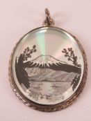 An unusual HM silver pendant having Japanese scene featuring Mount Fuji on silver background,