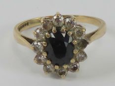 A 9ct gold sapphire cluster ring, the central blue sapphire approx 0.