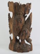 A carved rosewood Indo-Asian figurine of two figures in ceremonial dress, 31.5cm high.
