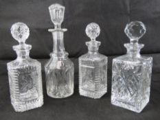 A quantity of four assorted decanters being a pressed glass pair complete with stoppers,