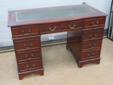 A reproduction pedestal desk having inset green leather writing surface, 122 x 60cm.