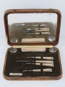 An Art Deco manicure set in 'crocodile skin' fitted box.