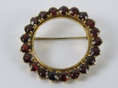 An 18ct gold and ruby brooch, stamped 750, 3.2cm dia, 8.2g.