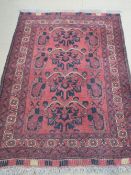 A wool and silk rug, red ground having Geometric design, 165 x 104cm.