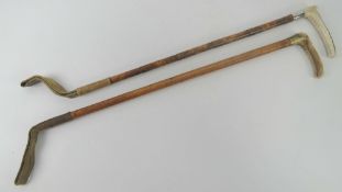 A pair of horn handled and bamboo riding crops one having HM silver collar,