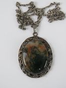 A large and impressive hallmarked silver natural moss agate pendant in floral setting,