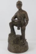 A heavy brass figurine of a miner in hat carrying lantern and pick axe, 31cm high.