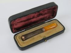 A superb 9ct rose gold and guilloche enamelled cigarette holder / cheroot having amber mouthpiece