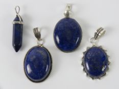 Four lapis lazuli pendants in white metal mounts, three stamped 925, measuring 4-5cm each inc bale.