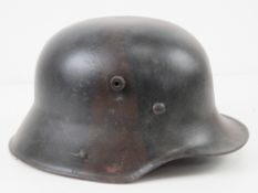 A WWI German M17 helmet having repainted camouflage, no chin strap.
