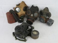 A quantity of four gas masks inc a WWII British Military long tube version,