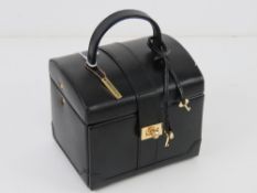 A contemporary black leather jewellery case having various compartments within.