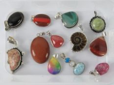 A quantity of assorted hardstone and fossil pendants inc goldstone pendant stamped 925 and