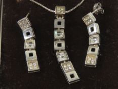 A suite of silver jewellery comprising articulated square sectional pendant set with white stones,