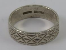 A HM silver ring having continuous engraved pattern to the 6mm wide band, hallmarked Birmingham,