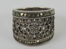 A silver ring set with marcasites and white stones, wide front measuring 1.