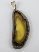 A large and unusual 'egg yolk' amber specimen pendant, stamped 925, 6cm in length.