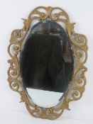An oval bevelled edge wall mirror in gold painted frame 52 x 37cm.