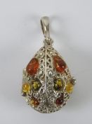 A silver and Baltic amber pendant in the form of a hinged egg, stamped 925, 4.5cm inc bale.