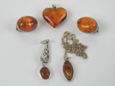 Three Baltic amber and silver pendants, one in Celtic style,