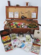 A wooden box containing a large quantity of fly tying apparatus within including hooks, thread,