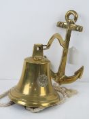 A brass wall mounted bell having anchor shaped wall mounting,