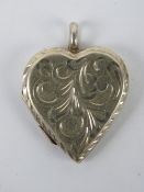 A HM silver locket in the form of a heart having scrolling vine engraving to front,