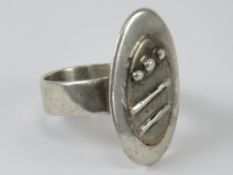 A white metal abstract design ring, no apparent hallmarks, size T-U.