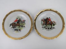 A pair of hunting themed decorative plates featuring huntsman on horseback with hounds at feet,