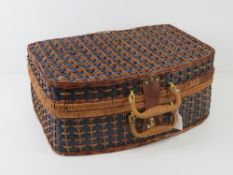 A wicker picnic basket with contents.