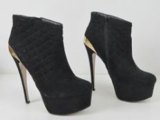 A pair of black velvet platform ankle bo