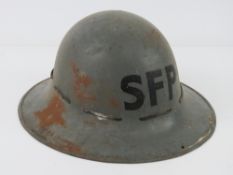 A WWII British SFP helmet with liner and chin strap, dated 1941.