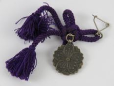 A WWII Japanese pin with rope in box.