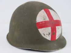 A WWII US medics helmet having liner and chin strap.