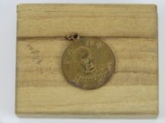A WWII Japanese medal with a face of the emperor in box.