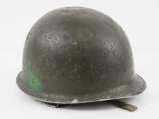 A WWII US helmet having liner and chin strap.