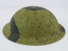 A WWII British helmet, having chin strap hooks either side, strap deficient.