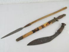 A Kukri with wooden handle together with an Oriental style dagger and an African short spear.
