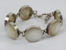 A mother of pearl bracelet having T-bar clasp, no apparent hallmarks, 20cm in length.