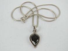 A teardrop shaped garnet pendant, stamped 925 on a 925 silver snake link articulated chain,
