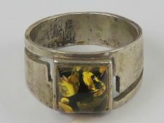 A silver an Baltic amber ring, the wide graduated band measuring 1.